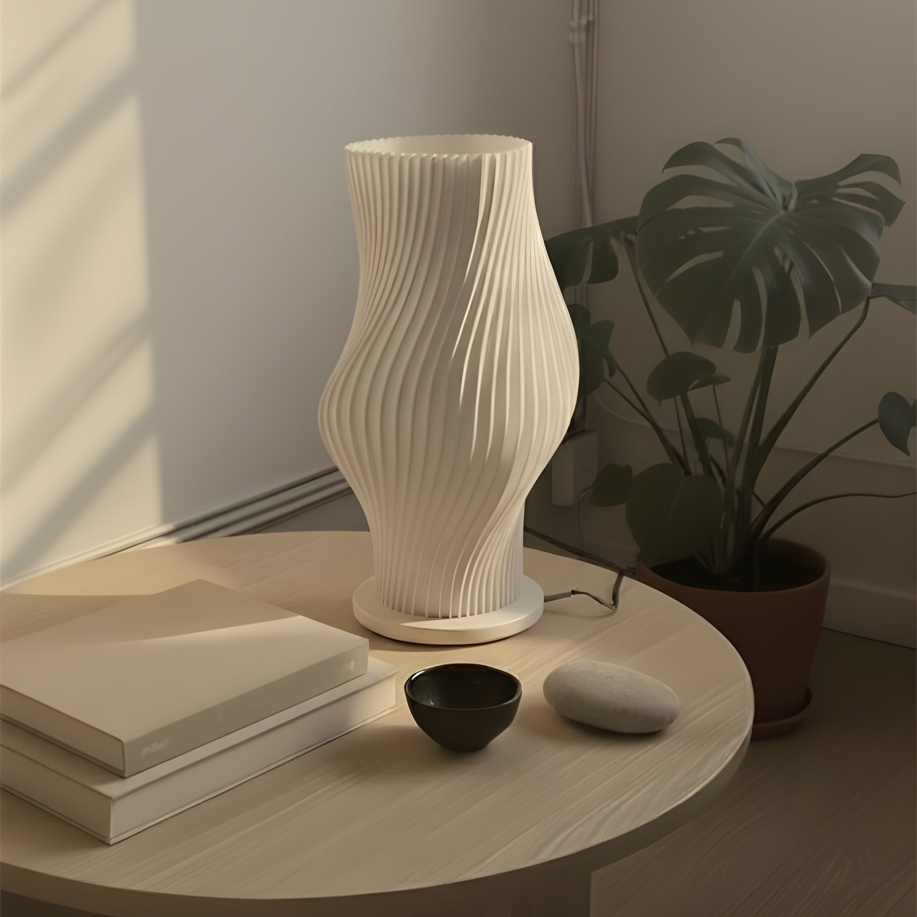 White textured vase on a wooden table with books and a plant in a dimly lit room